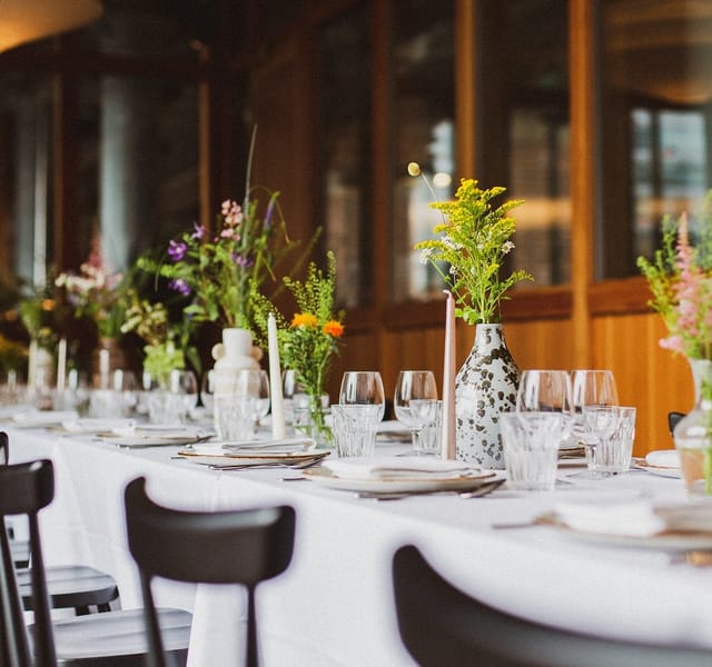 Elegant dining setup with floral centerpieces for corporate events in Dulcie Street Warehouse.