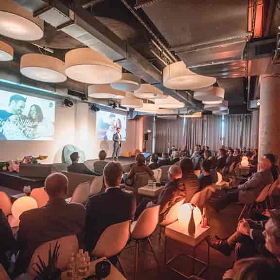 Event space at Pier 1, Westhafen: modern decor, speaker engaging audience, networking event.