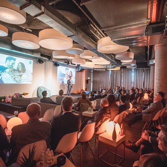 Event space at Pier 1, Westhafen: modern decor, speaker engaging audience, networking event.