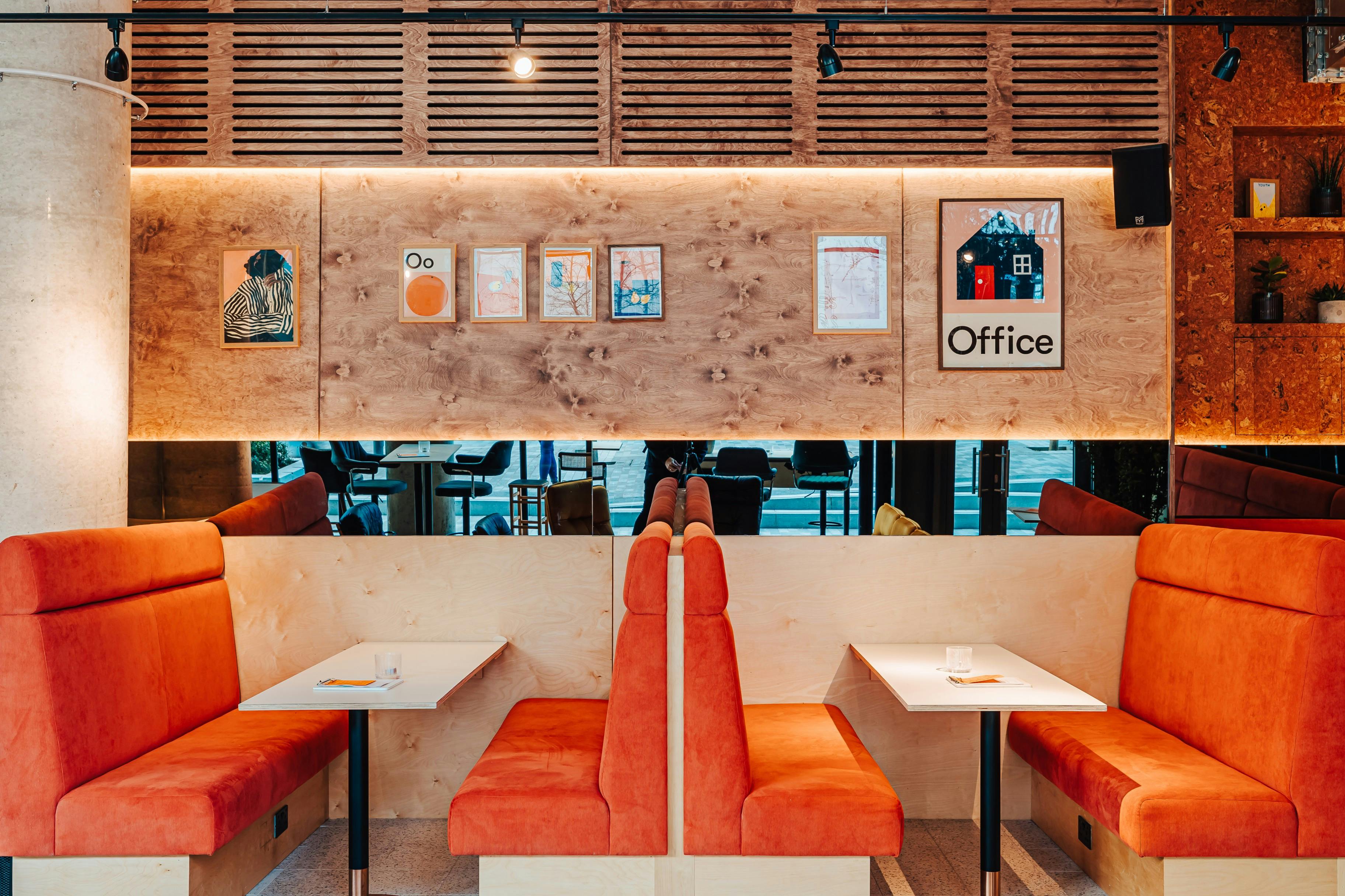 Modern Mezzanine in Someday with vibrant orange seating for casual meetings and events.