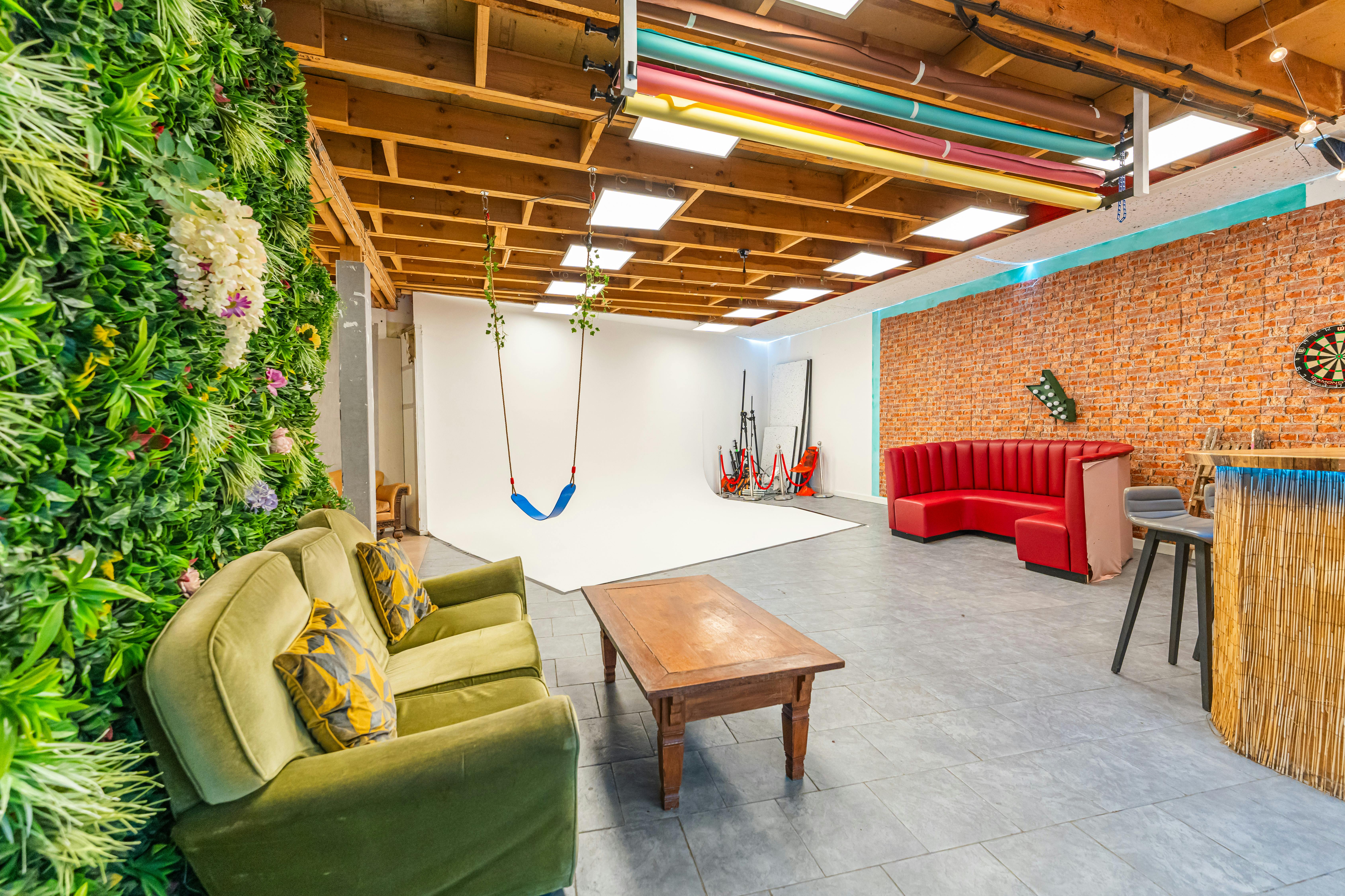 Versatile event space at 6 Degrees Studios with greenery wall for creative gatherings.