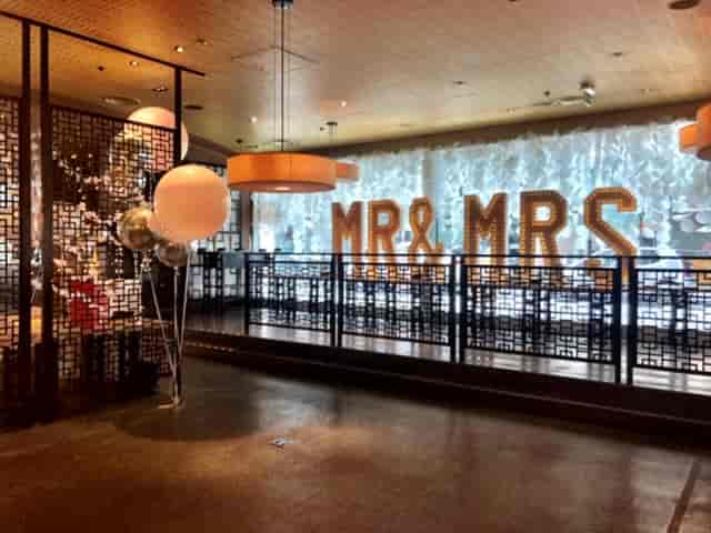 Elegant wedding reception space with "MR & MRS" backdrop and festive decor.