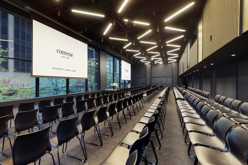 Modern event space with black chairs and screens, perfect for conferences and workshops.