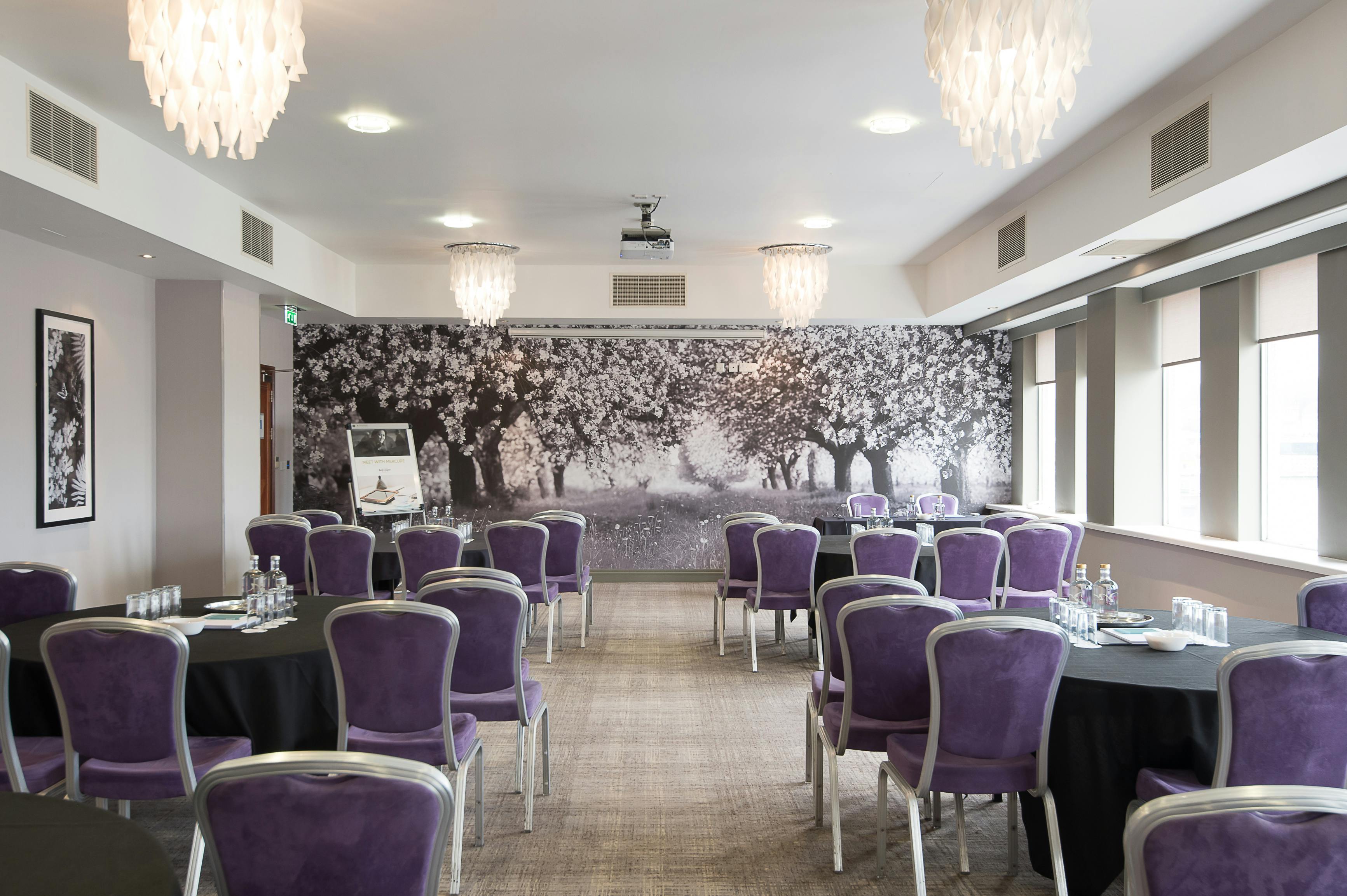 Elegant meeting room with purple chairs, ideal for workshops and conferences.