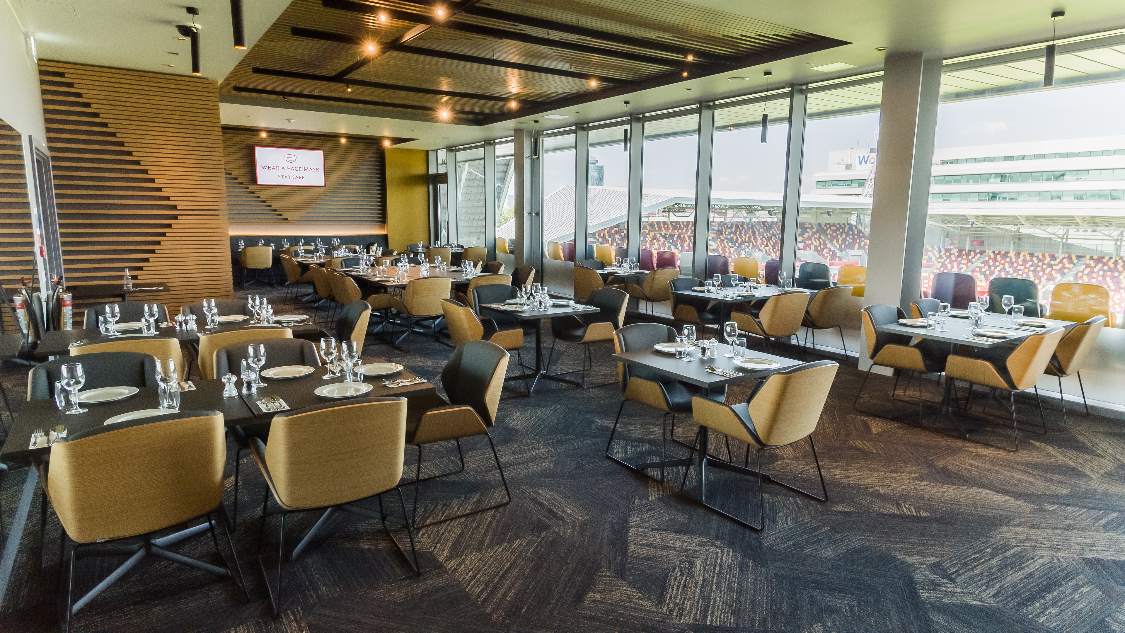 Modern event space at Brentford FC with elegant dining setup for corporate meetings. - Banner
