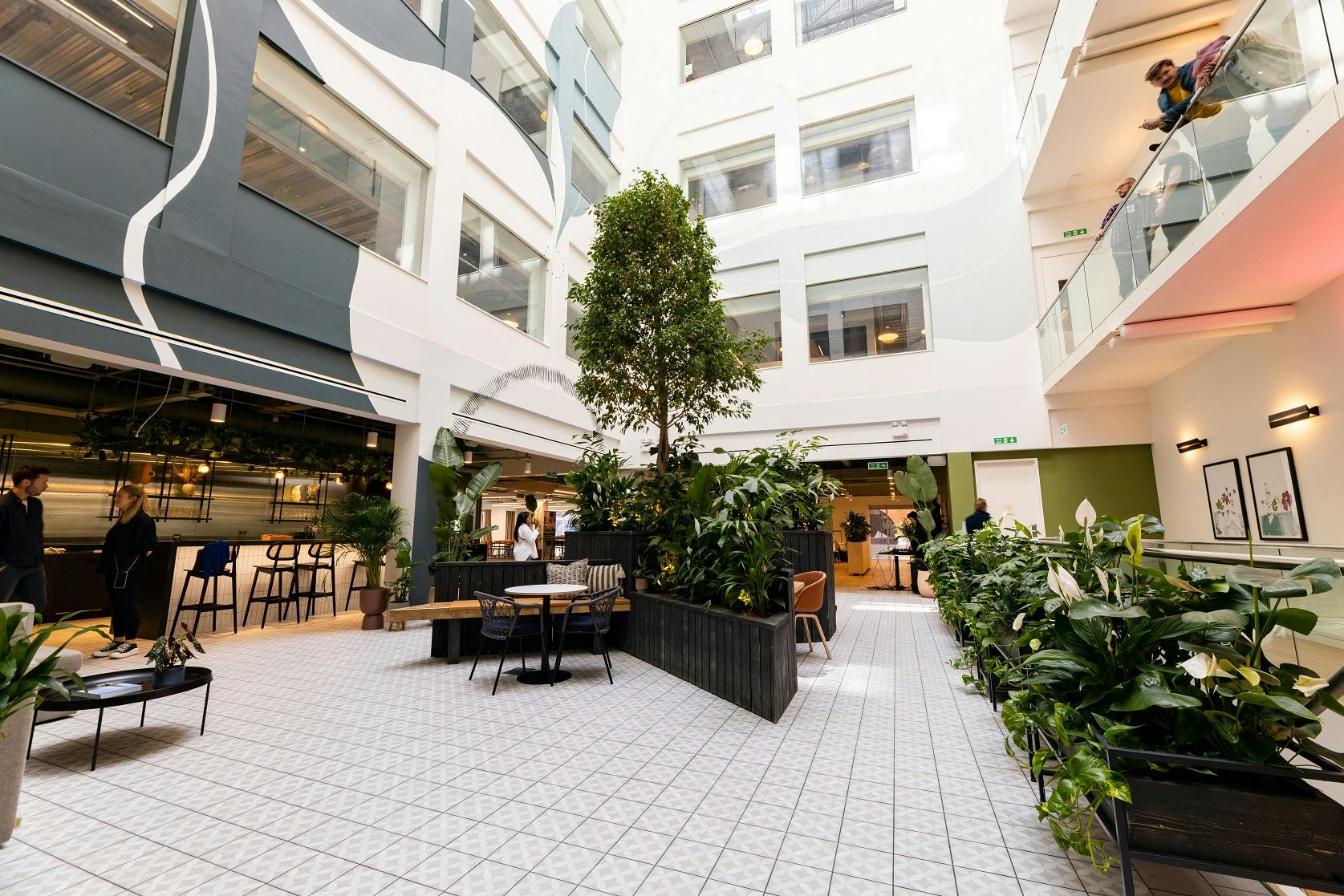 Modern open atrium with greenery, ideal for networking events and casual meetings.