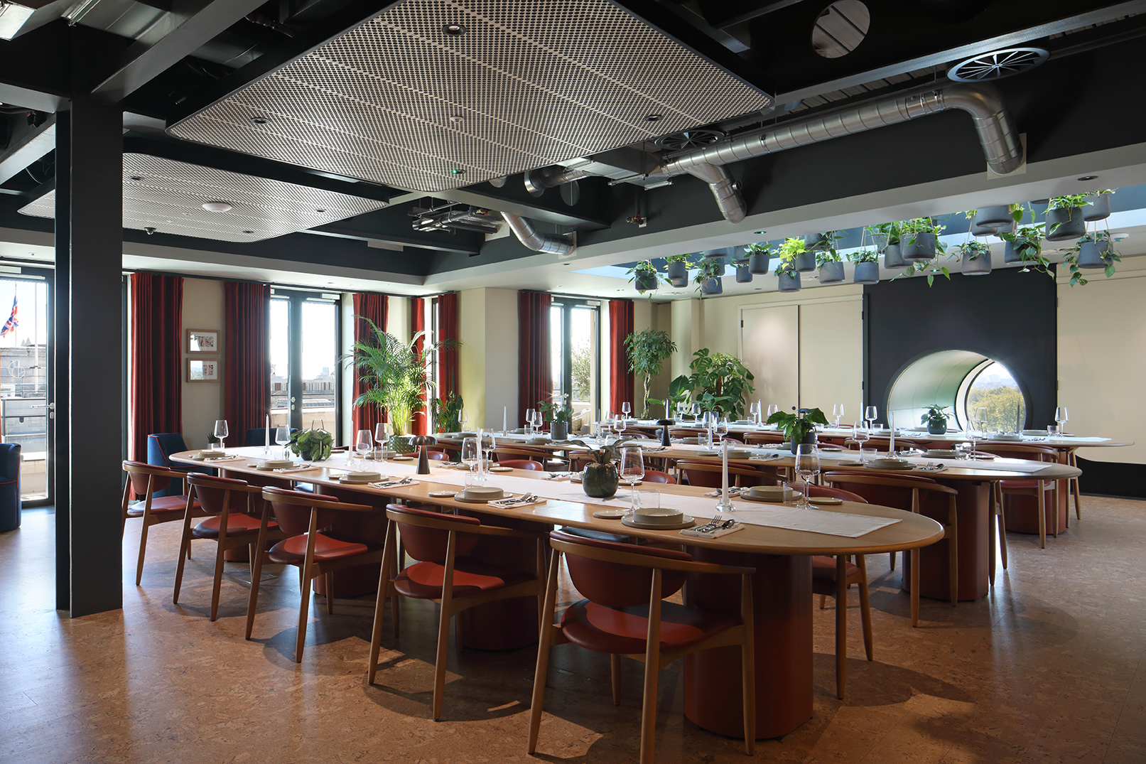 Modern event space with long tables and greenery for meetings and gatherings. - Banner