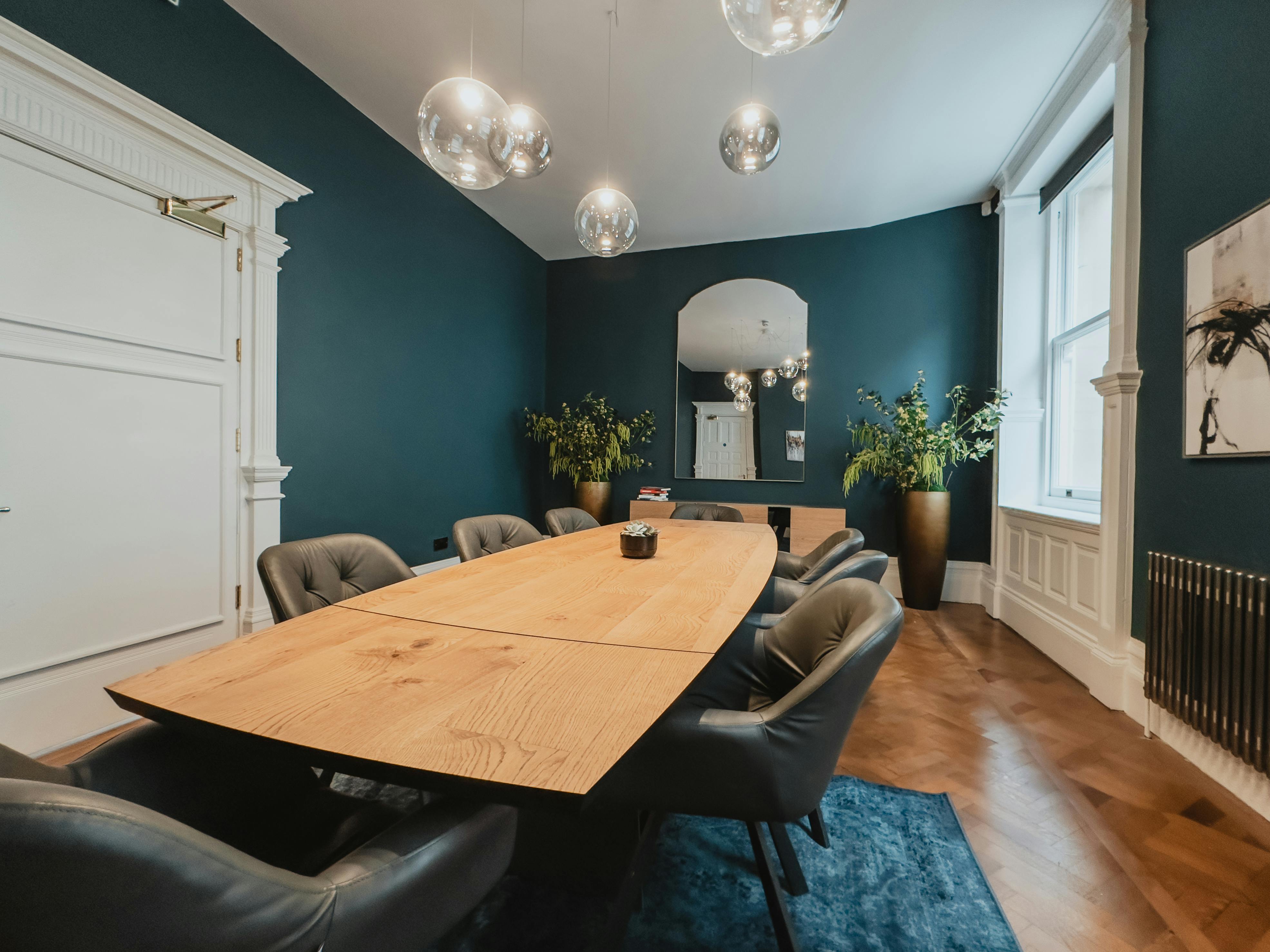 Stylish meeting room at The Clifton, featuring a long wooden table and modern decor.