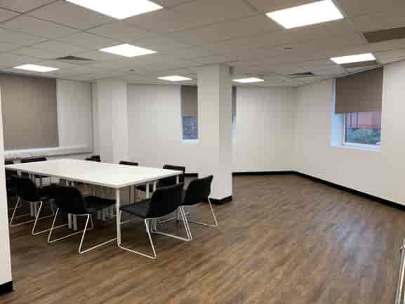 Modern meeting room with large white table, ideal for workshops at My Fair Lady Studio.