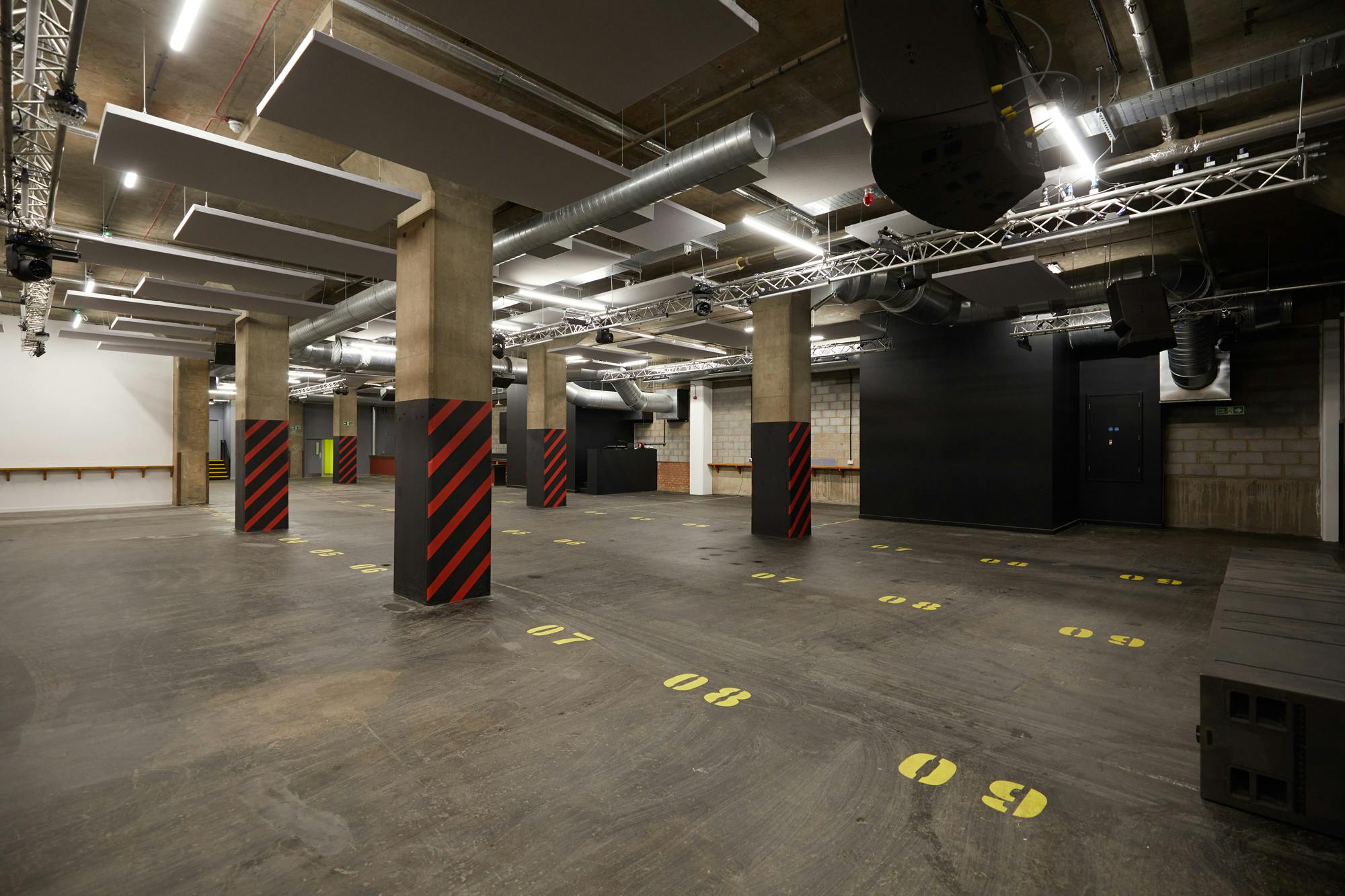 Versatile industrial event space with exposed concrete for conferences and workshops.