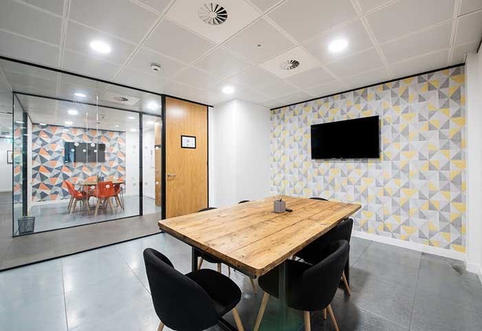 Modern meeting room with wooden table and black chairs at Runway East Bristol Bridge.