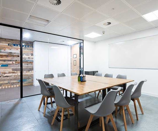 James in a modern meeting room with a wooden table, ideal for brainstorming sessions.