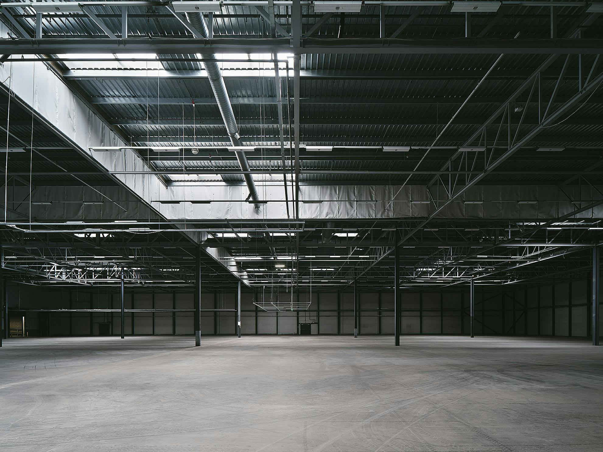 Spacious industrial venue with high ceilings for corporate events and trade shows.