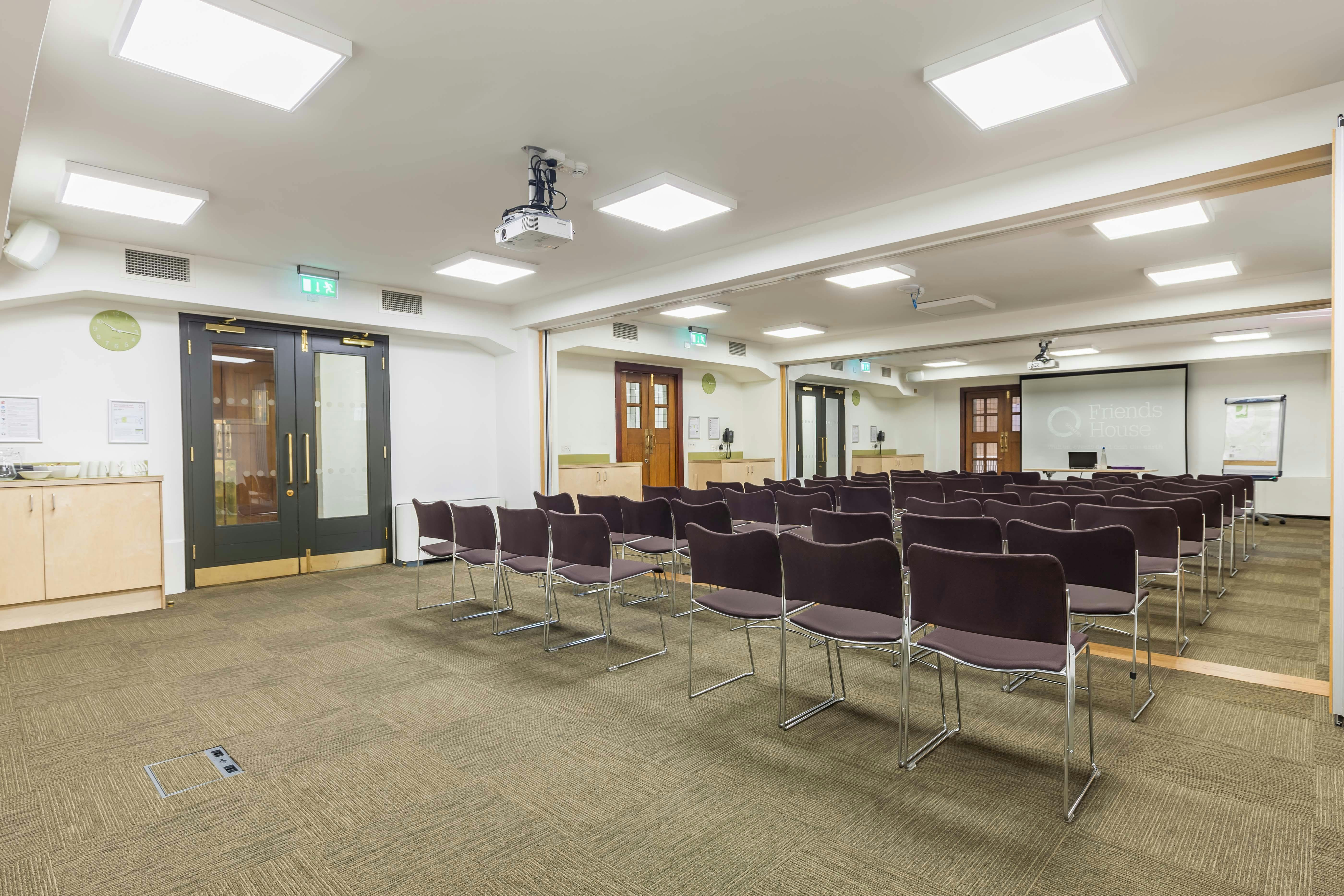 Ada Salter Suite meeting room with chairs and projection screen for corporate events.