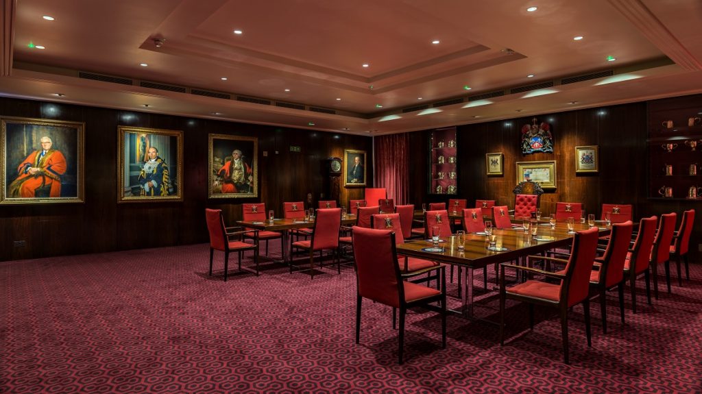 Formal boardroom with red upholstery for high-stakes business meetings and private corporate events.