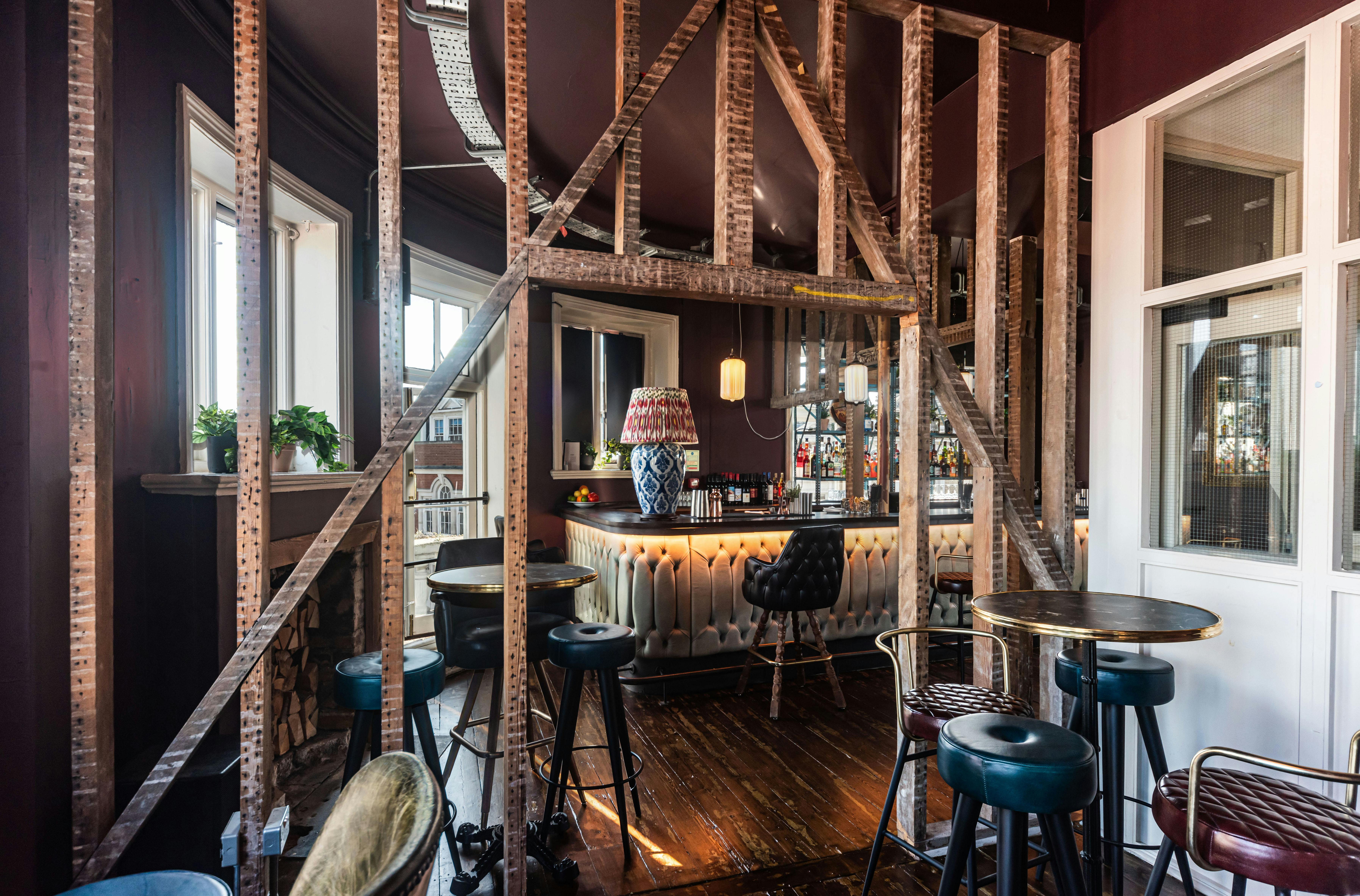 Stylish cocktail bar with wooden beams, ideal for networking events and casual meetings.