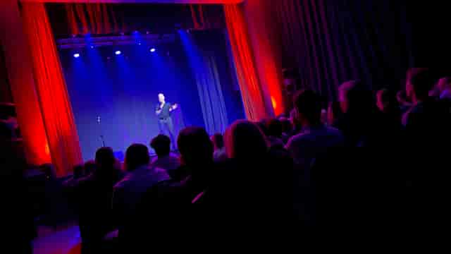 Esher Theatre stage with speaker, ideal for conferences and performances.
