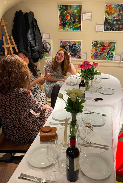 Vibrant networking event at Egro' London with elegant table settings and colorful artwork.