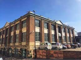 Spacious industrial venue with large windows for corporate events and social gatherings.