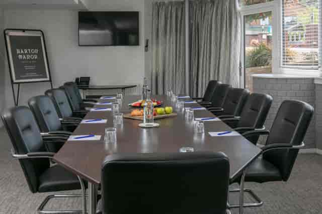 Genius Room at Barton Manor: polished meeting table, ideal for professional events and presentations.
