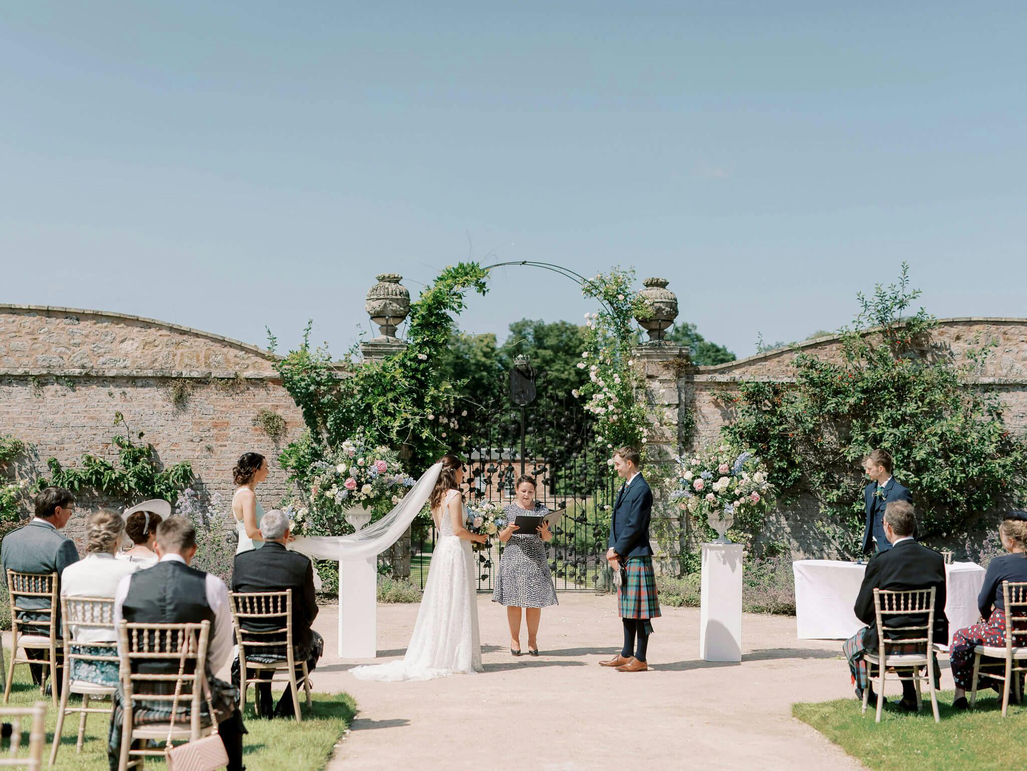 Georgian Walled Garden wedding altar with floral decor and lush greenery.