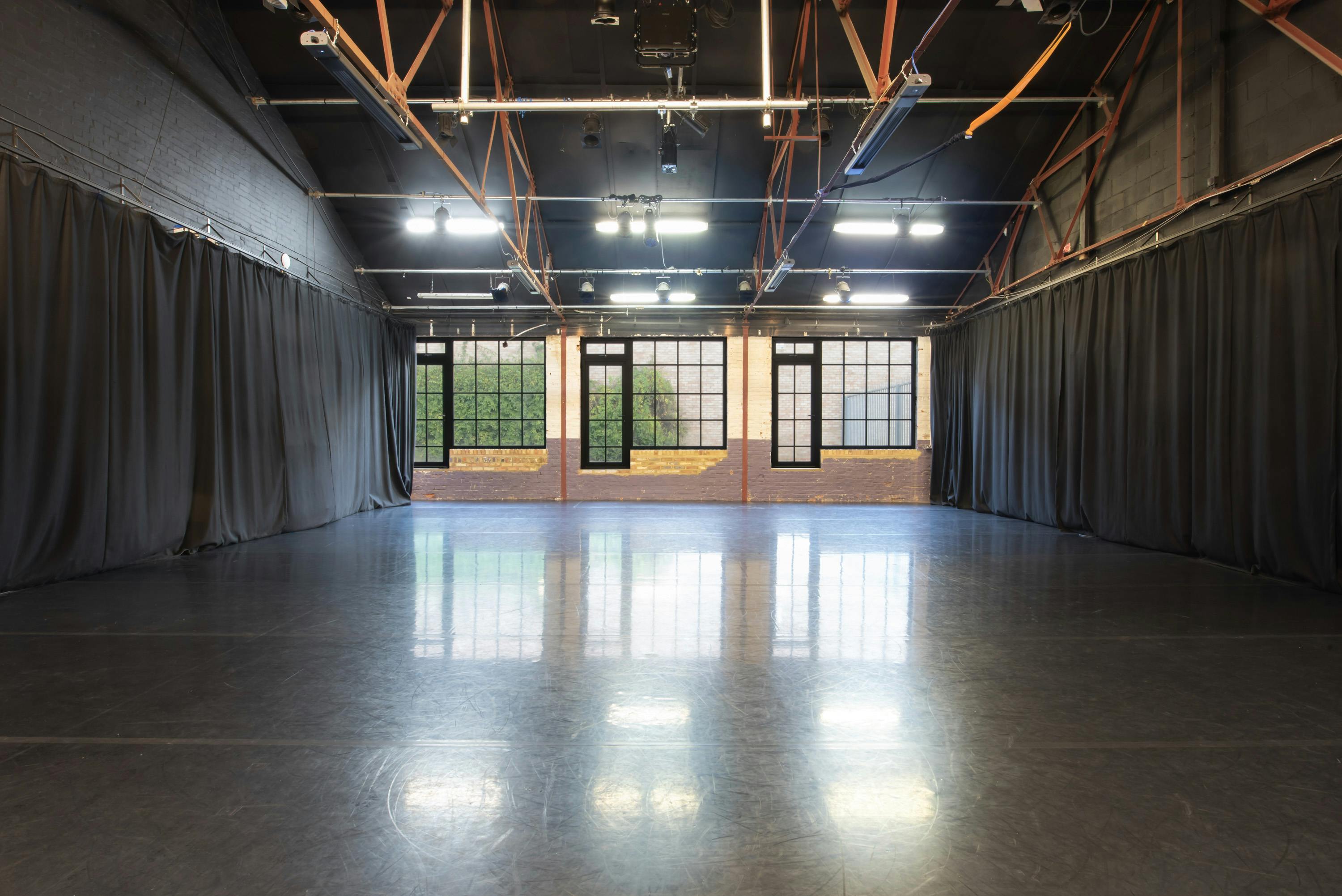 Versatile event space with polished floors and natural light for workshops and gatherings.