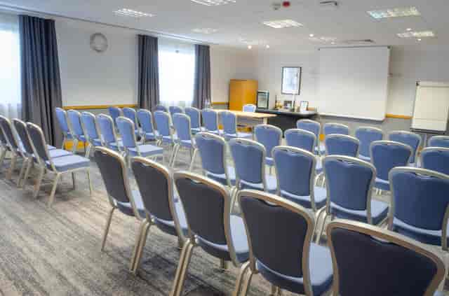 Hawksworth Suite meeting room with blue chairs, perfect for presentations and events.