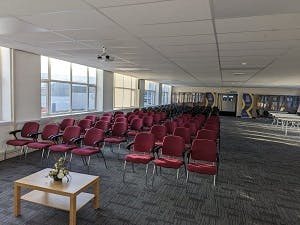 Spacious Main Hall with maroon chairs, ideal for meetings and events in Rethink Rebuild Society.