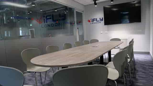Modern conference room with oval table at iFLY Indoor Skydiving, ideal for corporate events.