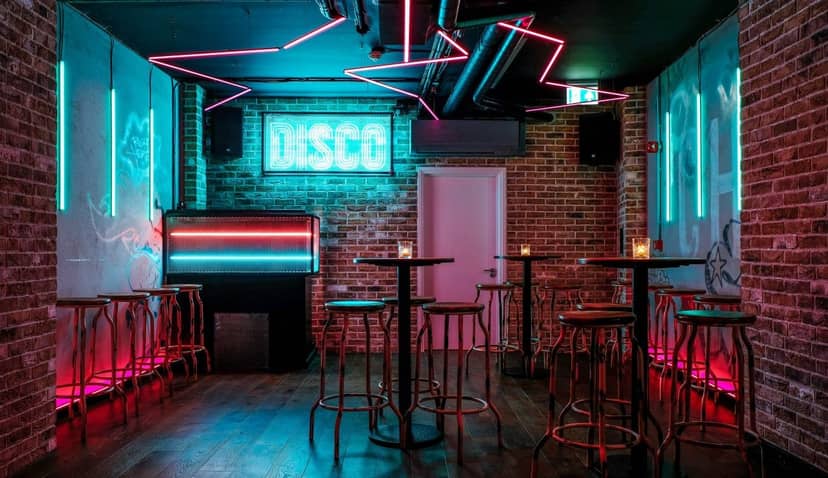 Vibrant Simmons Bar with neon lights, ideal for social gatherings and networking events.