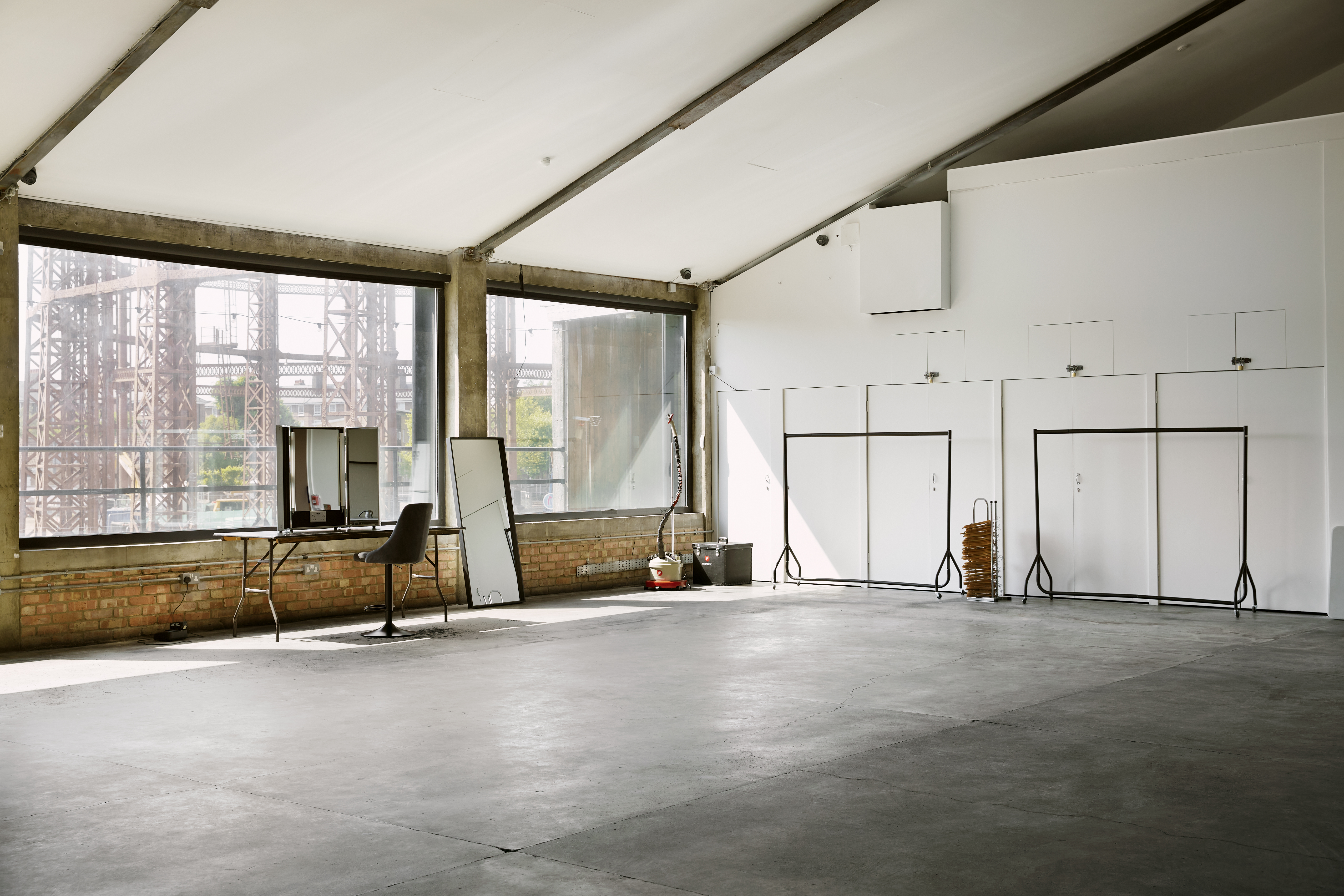 Spacious industrial venue with large windows for corporate events and social gatherings. - Banner