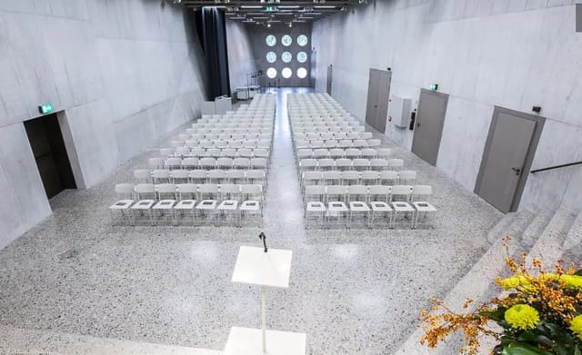 Modern auditorium with clear chairs and circular windows for conferences in Zurich.