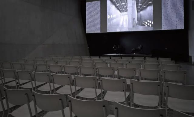 Auditorium Willy GS Hirzel: minimalist event space with empty white chairs for presentations.