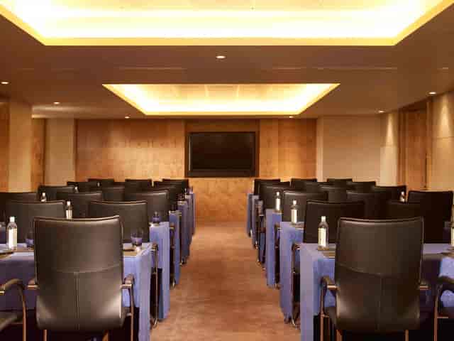 Modern meeting room with black chairs and blue table covers at The Landmark London.