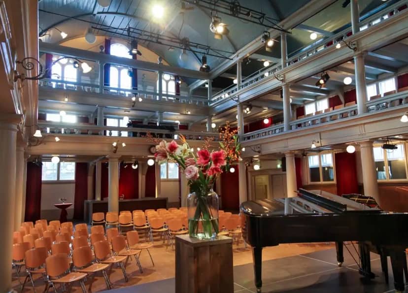 Oosterhuiszaal event space with grand piano, ideal for corporate and social gatherings.