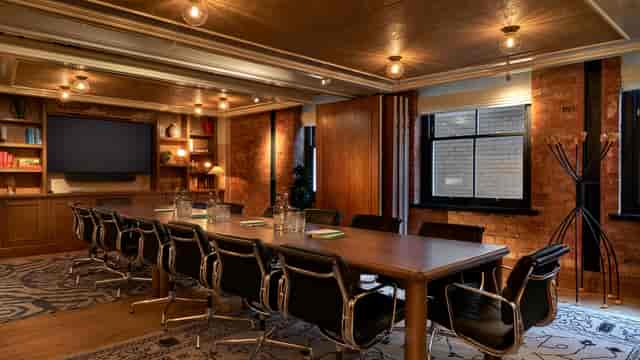 Modern conference room at 1 WARWICK with wooden table, ideal for meetings and presentations.