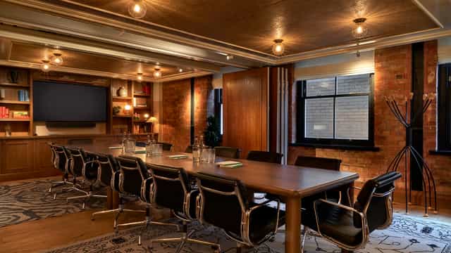 Modern conference room at 1 WARWICK with wooden table, ideal for meetings and presentations.