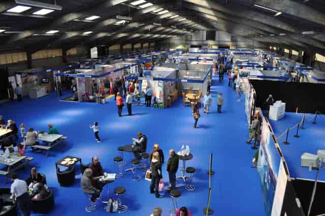 Royal Cornwall Events Centre bustling exhibition with vibrant blue flooring, ideal for networking.