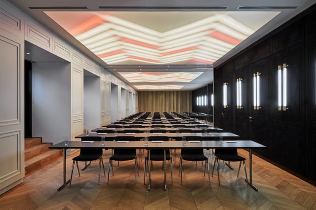 Modern meeting room in Roomers Munich with stylish tables and chairs for versatile events.