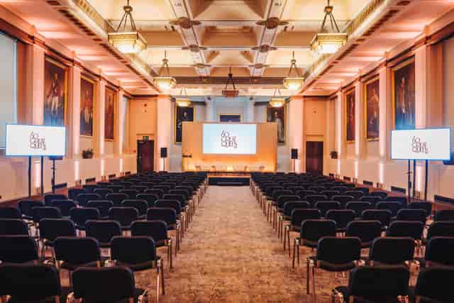 Theater-style event setup at 60 Great Queen Street with integrated AV screens for presentations.