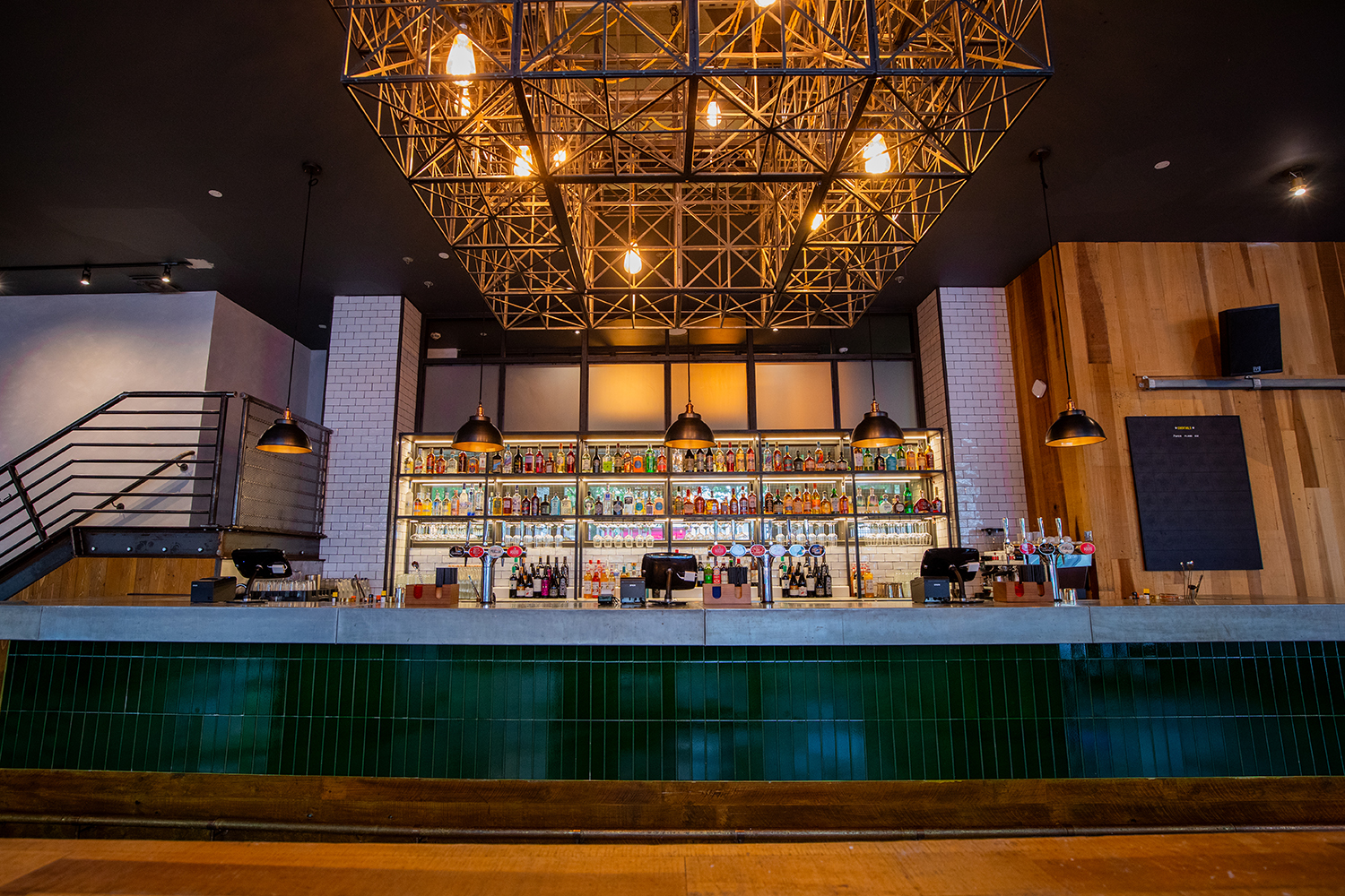 Stylish bar area with geometric light fixture for networking events and cocktail receptions.