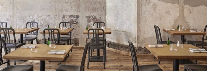 Minimalist dining space with wooden tables, ideal for intimate events and gatherings.