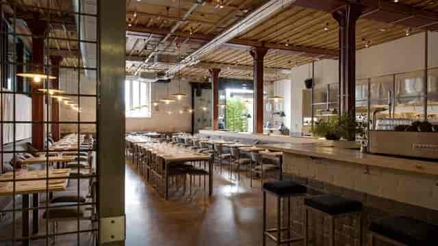 Spacious modern event venue with high ceilings, ideal for networking and gatherings.