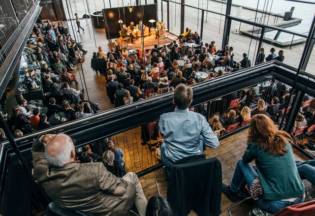 Panel discussion in Royal Danish Theatre's Playhouse Foyer, modern venue, networking event.