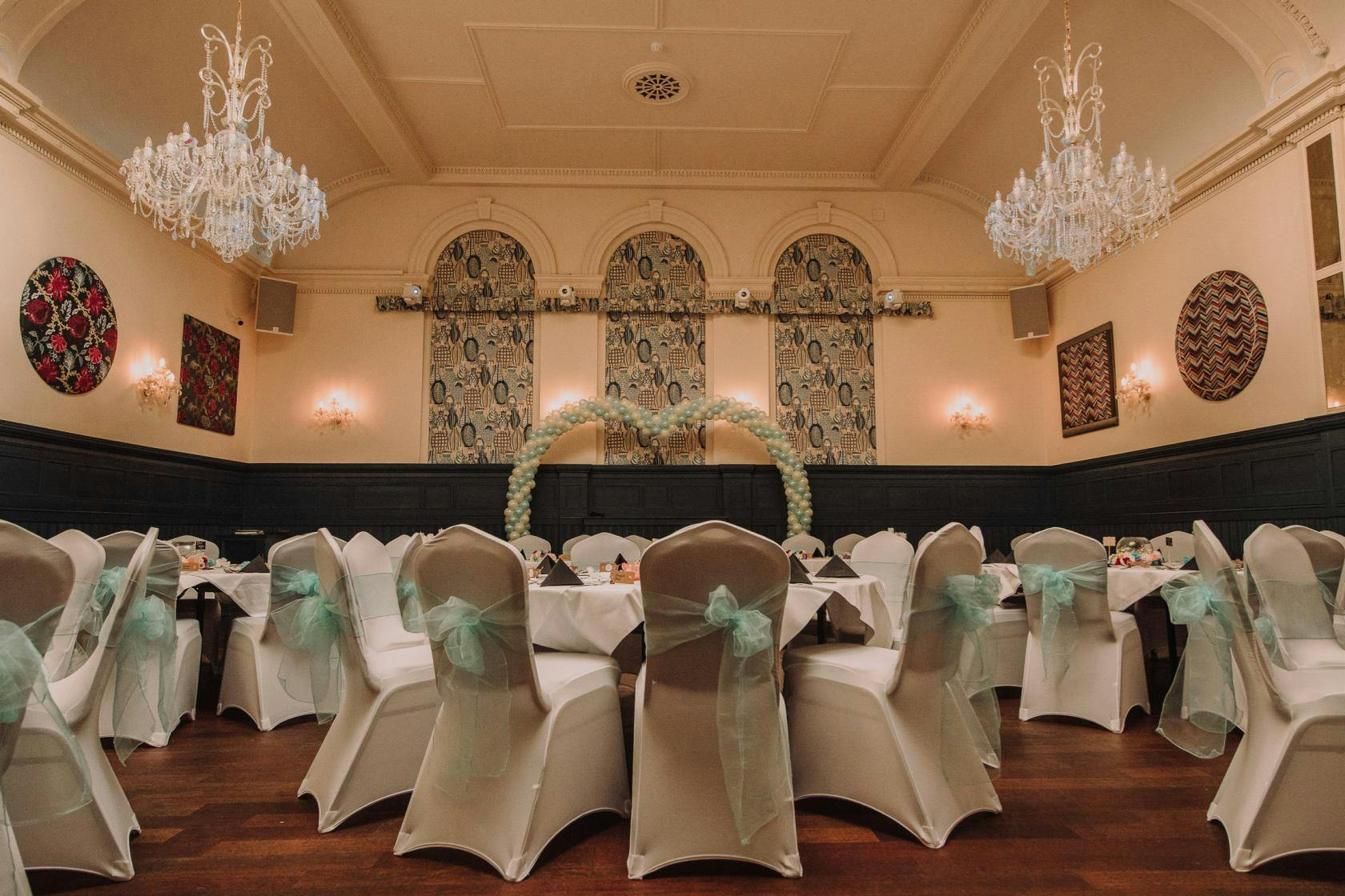 Elegant banquet hall with chandeliers, perfect for weddings and formal events.