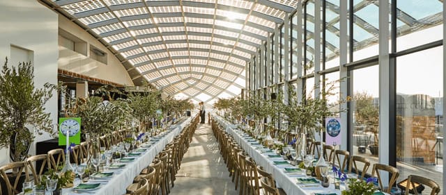 Elegant banquet table with floral centerpieces in bright venue for weddings or corporate events.