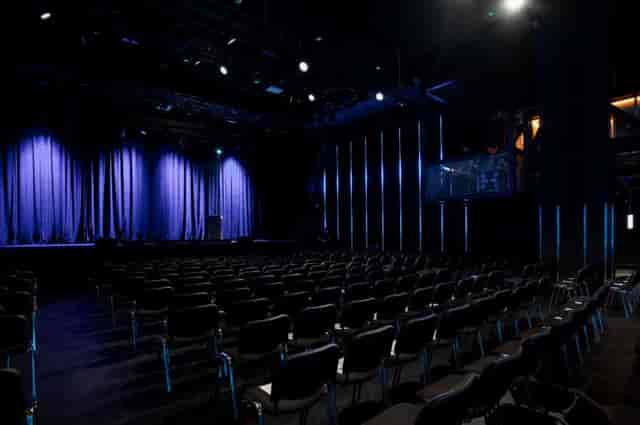 Event space at Outernet London with blue curtains, ideal for conferences and performances.