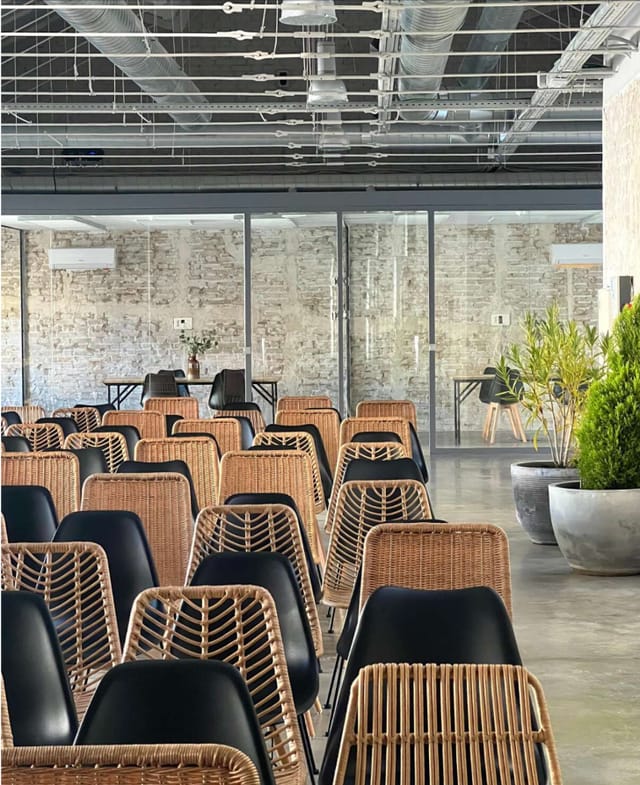 Modern event space with wicker chairs, ideal for workshops and gatherings.