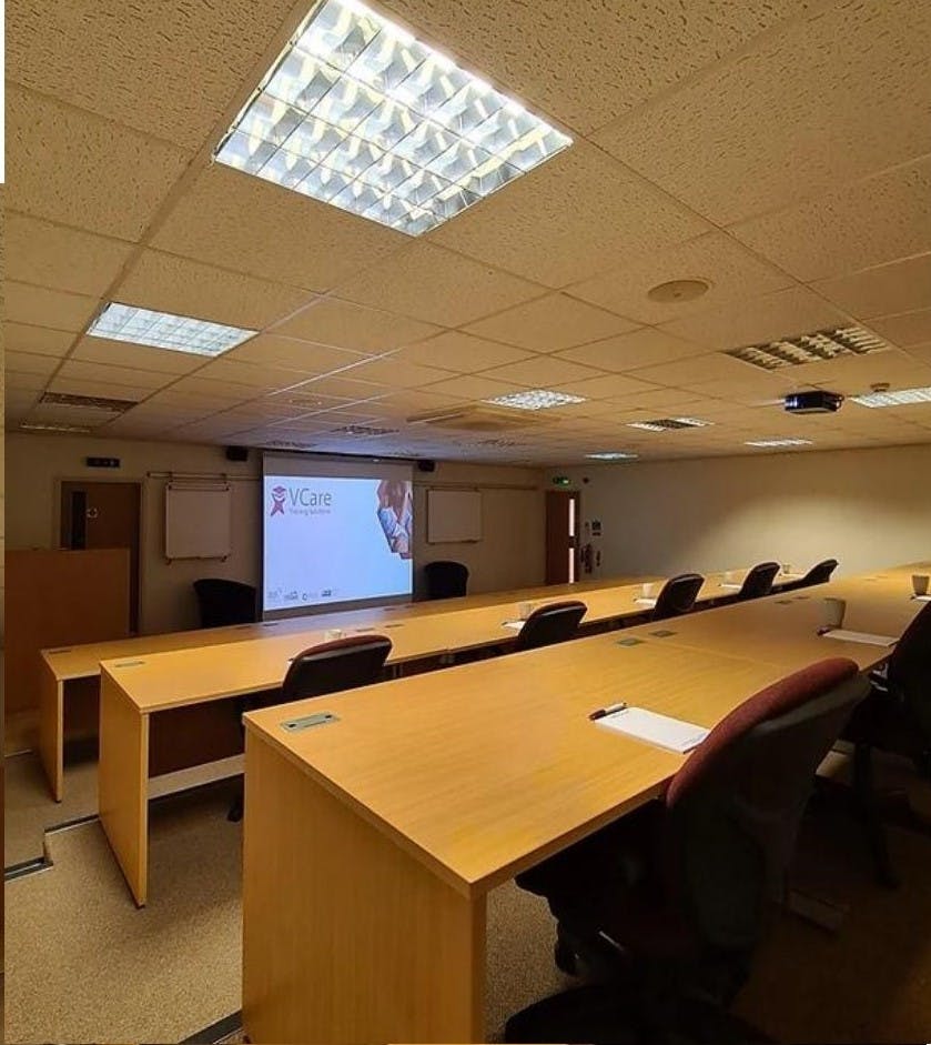 Auditorium/Boardroom at Vcare24, featuring a projector screen for workshops and training.