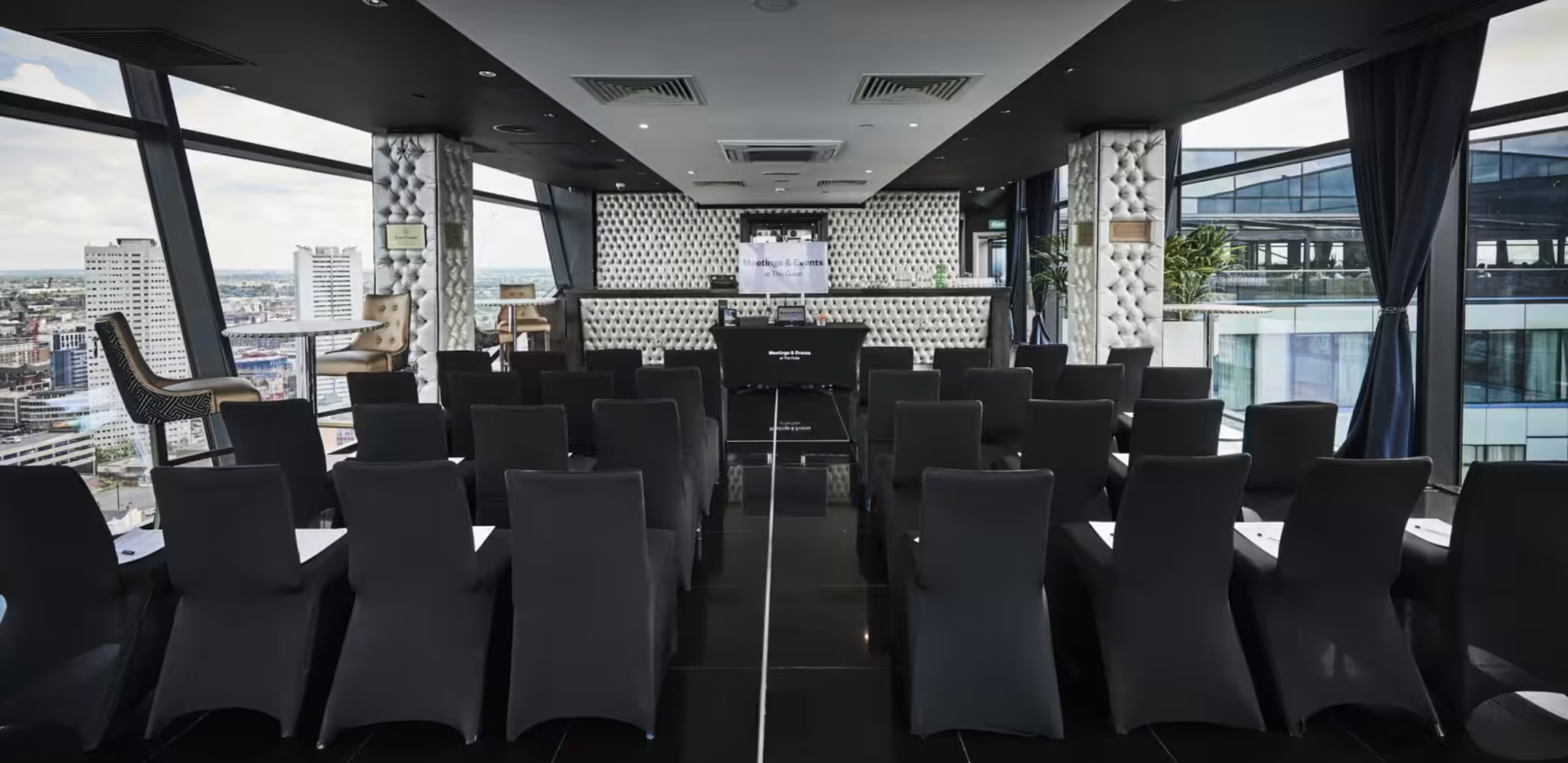 The Champagne Room at The Cube Hotel, modern event space with black chairs and natural light. - Banner